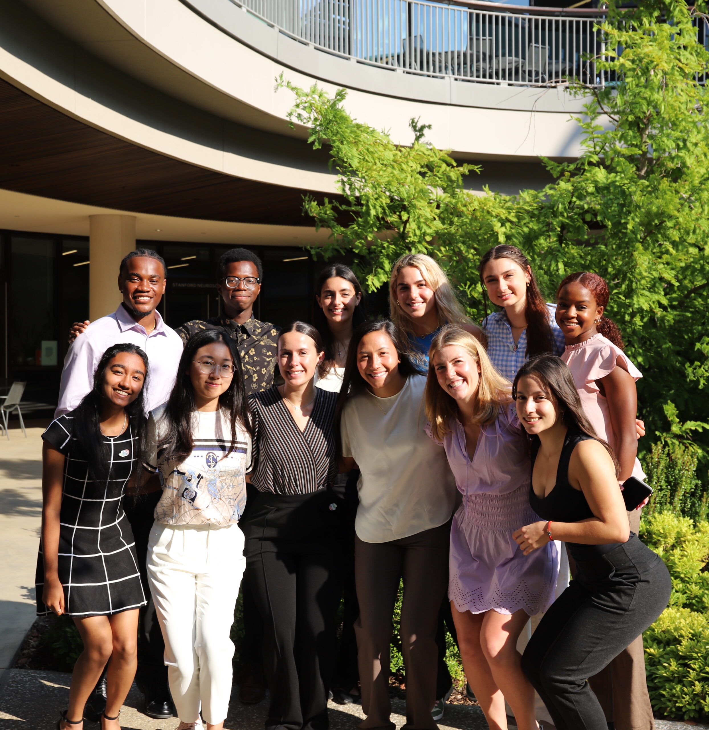 12 undergraduate scholars smiling together outdoors